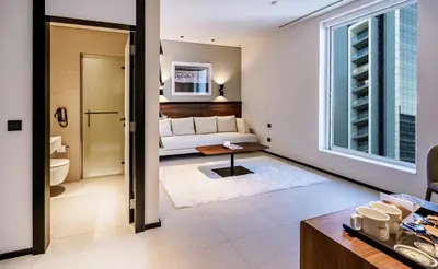 a living room with a couch and a table at FORM Hotel Al Jaddaf, Dubai, a Member of Design Hotels in Dubai