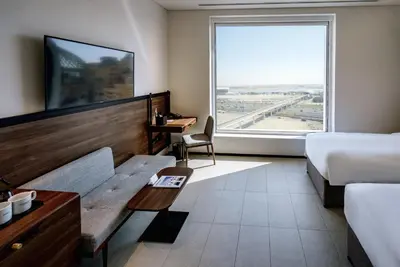 a hotel room with a bed and a large window at FORM Hotel Al Jaddaf, Dubai, a Member of Design Hotels in Dubai