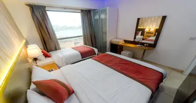 a hotel room with two beds and a mirror at Jbr beach walk 2 bedrooms front sea in Dubai