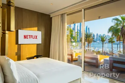 a hotel room with a bed and a view of the beach at FIVE Palm Beach Villa -Private Pool & Roopftop Jacuzzi, 3-Level, by Exclusive Holiday Homes in Dubai
