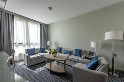 a living room with a couch and a table at Gulf Inn Hotel Al Nasr Formerly Roda Links Al Nasr in Dubai