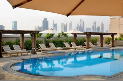 a swimming pool with a city skyline in the background at Crowne Plaza - Dubai Jumeirah by IHG in Dubai