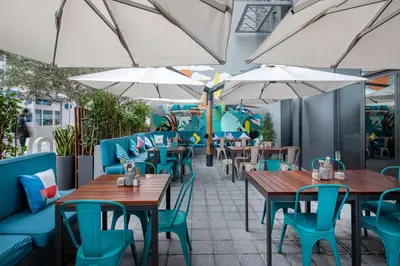 a restaurant with tables and chairs and umbrellas at Rove Dubai Marina in Dubai