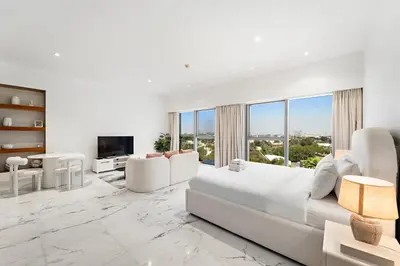 a white living room with a large white couch and chairs at Studio Central Park DIFC in Dubai