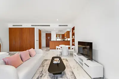 a living room with a white couch and a tv at Studio Central Park DIFC in Dubai