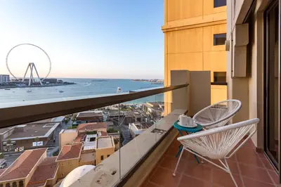 a balcony with a chair and a view of the ocean at ELAN Rimal 3 Suites in Dubai