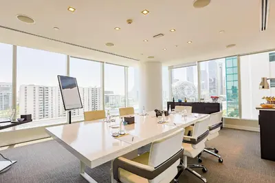 an office with a long table and chairs and windows at Nassima Tower Hotel Apartments in Dubai