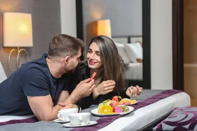 a man and woman sitting at a table with a plate of food at Nassima Tower Hotel Apartments in Dubai