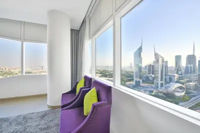a room with purple chairs and a large window at Nassima Tower Hotel Apartments in Dubai