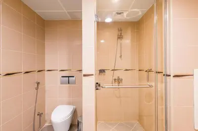 a bathroom with a shower with a toilet and a shower at Nassima Tower Hotel Apartments in Dubai