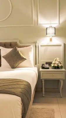 a hotel room with a bed and a table with a lamp at President Hotel in Dubai