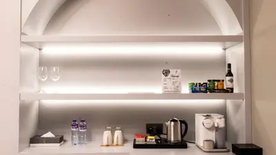 a shelf with wine glasses and a coffee maker at President Hotel in Dubai