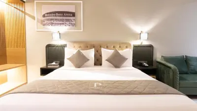 a bedroom with a large bed and a green chair at President Hotel in Dubai