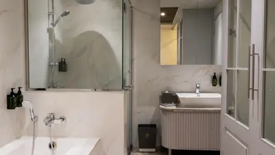 a white bathroom with a sink and a shower at President Hotel in Dubai