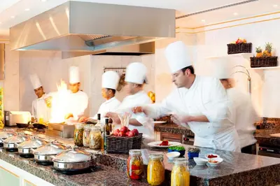 a group of chefs in a kitchen preparing food at Kempinski Hotel Palm Jumeirah in Dubai