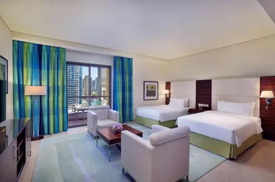 a hotel room with two beds and a television at Hilton Dubai The Walk in Dubai