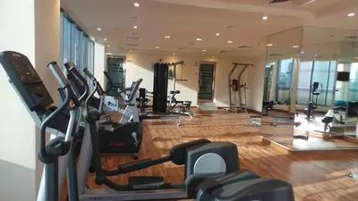 a gym with treadmills and ellipticals in a building at Xclusive Maples Hotel Apartment in Dubai