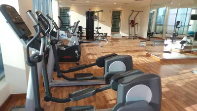 a gym with several treadmills and elliptical machines at Xclusive Maples Hotel Apartment in Dubai