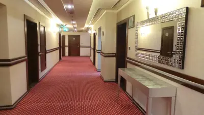 a corridor of a hallway with a red carpet at Xclusive Maples Hotel Apartment in Dubai