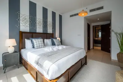 a bedroom with a large bed with blue and white stripes at Maison Privee - Exclusive Apt with Burj Khalifa Next Door in Dubai