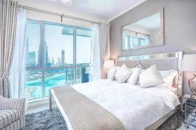 a bedroom with a large bed and a large window at Elite Royal Apartment - Burj Residences Tower 5 in Dubai