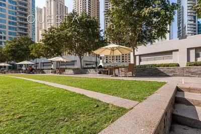 a park with an umbrella and a table and chairs at Park Island, Dubai Marina in Dubai
