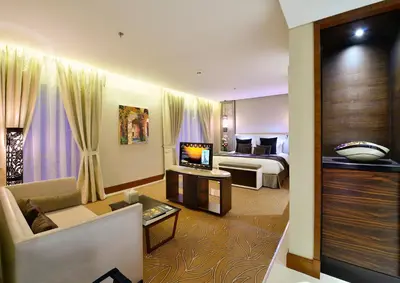 a hotel room with a bed and a living room at The Tower Plaza Hotel Dubai in Dubai