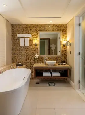 a bathroom with a tub and a sink and a mirror at The Tower Plaza Hotel Dubai in Dubai