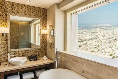 a bathroom with a toilet and a sink and a window at The Tower Plaza Hotel Dubai in Dubai
