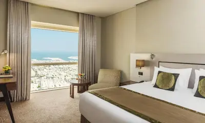 a hotel room with a bed and a large window at The Tower Plaza Hotel Dubai in Dubai
