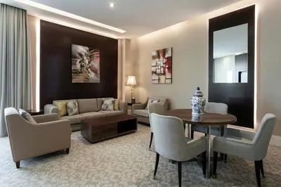 a living room with a couch and a table and chairs at Renaissance Business Bay Hotel, Dubai in Dubai