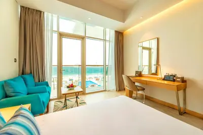 a hotel room with a desk and a bedroom at Royal Central Hotel and Resort The Palm in Dubai