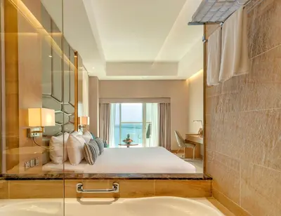 a bedroom with a bed with a window and a sink at Royal Central Hotel and Resort The Palm in Dubai
