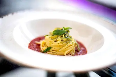 a plate of pasta with sauce and basil on top at Stella Di Mare Dubai Marina Hotel in Dubai