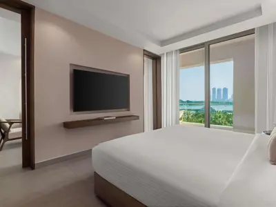 a bedroom with a bed and a flat screen tv at Rixos The Palm Hotel & Suites - Ultra All Inclusive in Dubai