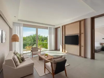 a living room with a couch and a tv at Rixos The Palm Hotel & Suites - Ultra All Inclusive in Dubai