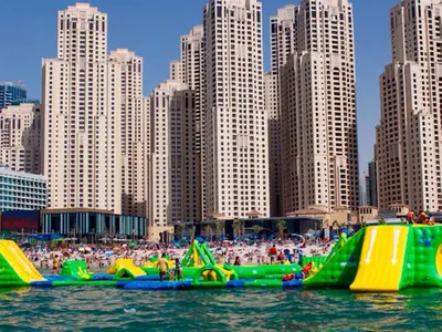 a group of inflatable slides in the water near a city at Murjan Suites Waterfront Jumeirah Beach Residence The Walk & Dubai Eye & Beach & Marina in Dubai