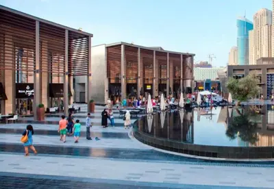 a group of people walking in front of a building with a fountain at Murjan Suites Waterfront Jumeirah Beach Residence The Walk & Dubai Eye & Beach & Marina in Dubai