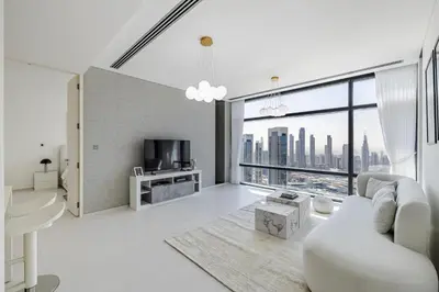 a living room with a white couch and a large window at 1BR Burj Khalifa View Index Tower DIFC in Dubai