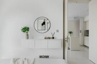 a white kitchen with a mirror on the wall at 1BR Burj Khalifa View Index Tower DIFC in Dubai