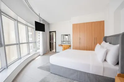 a bedroom with a large white bed and windows at Citadines Metro Central Dubai in Dubai