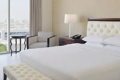 a hotel room with a bed and a chair and a window at Delta Hotels by Marriott Dubai Investment Park in Dubai