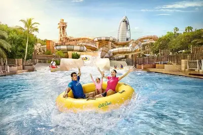 a group of people riding on a raft in a water park at Divine Burj & Opera Views - 2BDR - DOWNTOWN DUBAI in Dubai
