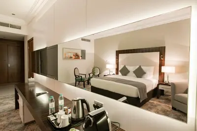 a hotel room with a bed and a desk at Elite Byblos Hotel in Dubai
