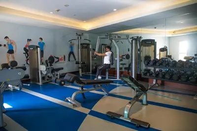 a man exercising in a gym with weights at Elite Byblos Hotel in Dubai