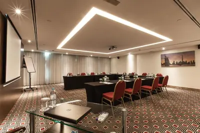 a meeting room with a long table and chairs at Elite Byblos Hotel in Dubai