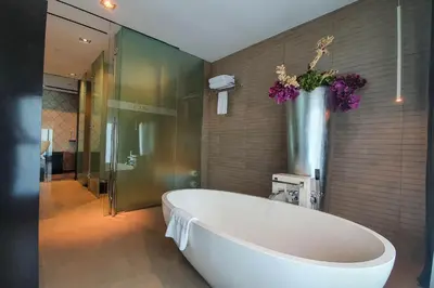 a large bath tub in a bathroom with flowers on the wall at The Canvas Dubai - MGallery Hotel Collection in Dubai