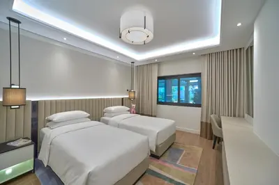 a hotel room with two beds and a window at Grand Hyatt Residence in Dubai