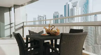 a table with chairs and a bowl of food on a balcony at City Premiere Hotel Apartments - Dubai in Dubai