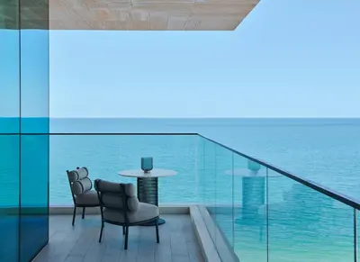 a balcony with a table and chairs and the ocean at Mandarin Oriental Jumeira, Dubai in Dubai